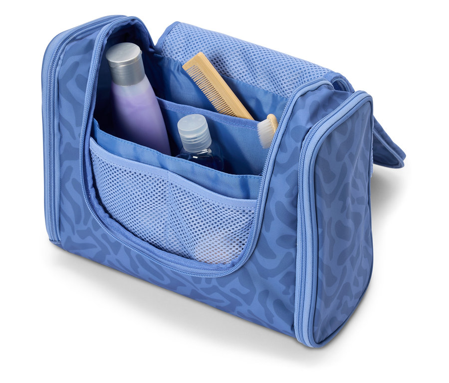 Trousse de toilette ouverte bleu clair contenant divers articles de voyage tels que du shampoing, un peigne et une brosse à dents.