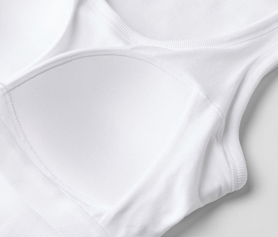 Gros plan d'un soutien-gorge de sport blanc avec coussinets amovibles et dos nageur.