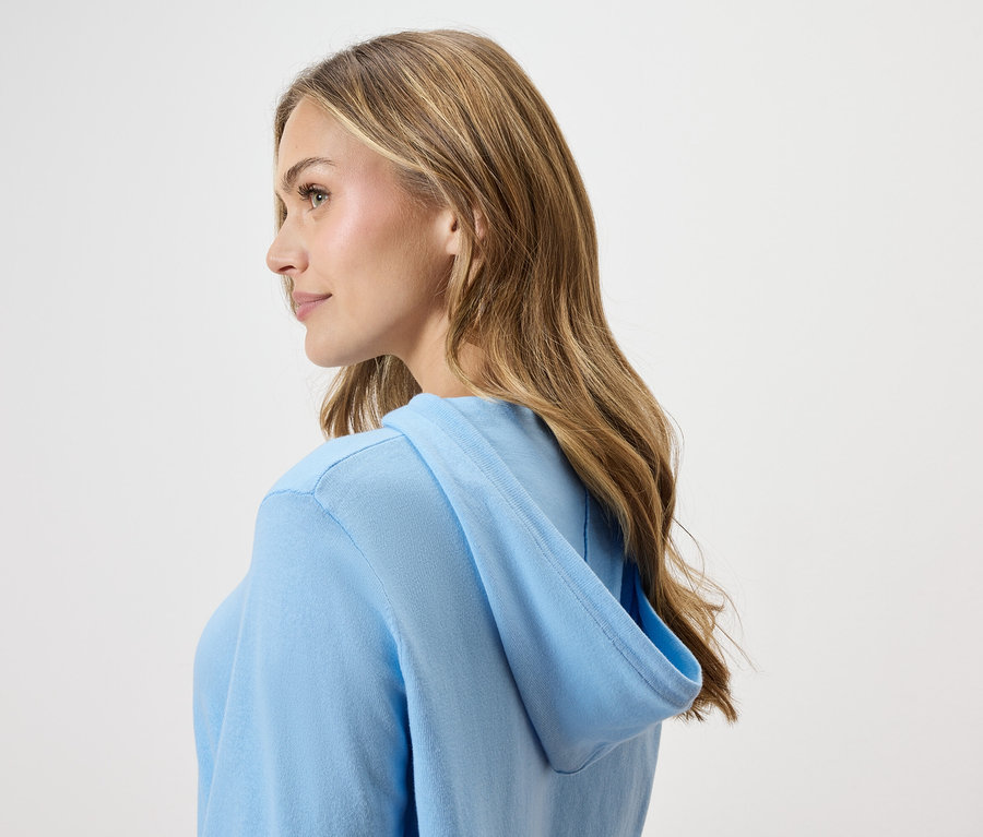 Femme portant un sweat à capuche bleu clair, vue de profil.
