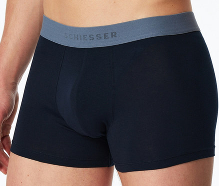 Un homme porte un boxer SCHIESSER bleu foncé avec une ceinture grise.