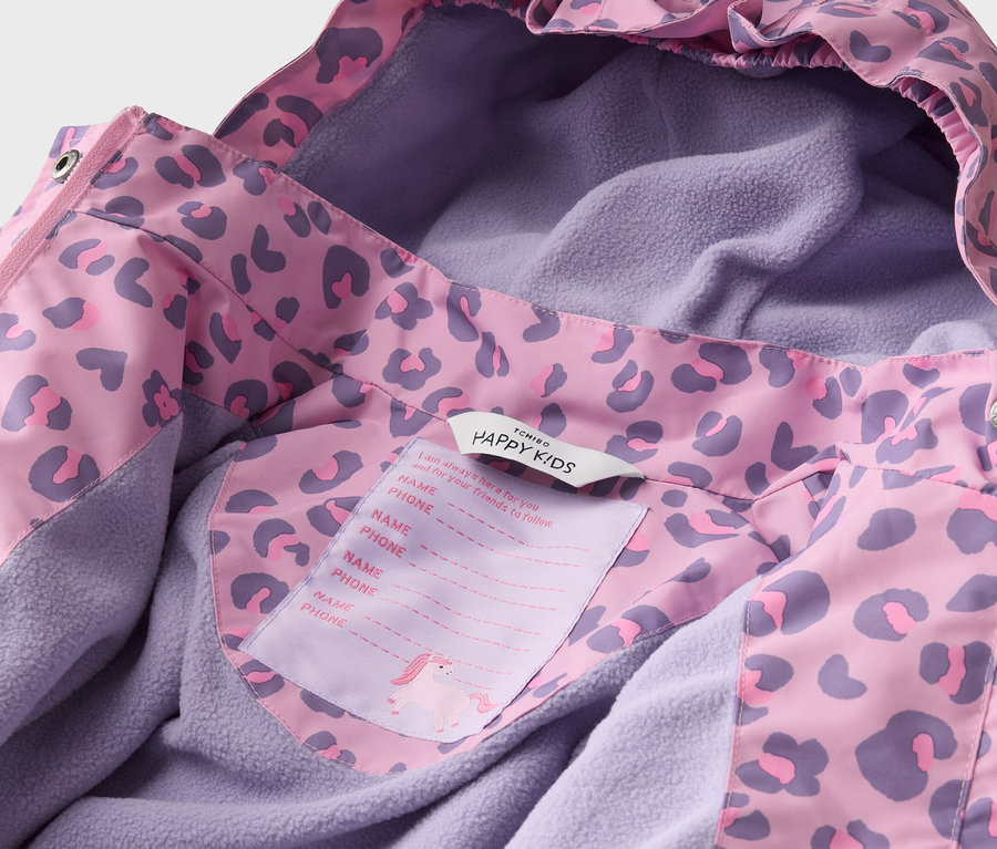 Vue intérieure d'une veste pour enfant rose à motif léopard avec une doublure en polaire violette. Une étiquette avec l'inscription "HAPPY KIDS" et un espace pour les coordonnées est visible.