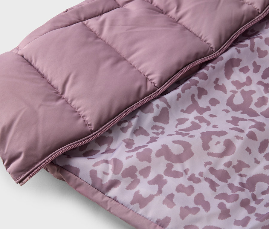 Gros plan d'une veste matelassée rose avec fermeture éclair et motif léopard à l'intérieur.