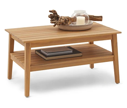 Une table basse en bois à deux étages avec des livres sur l'étagère inférieure et des bougies sur l'étagère supérieure.