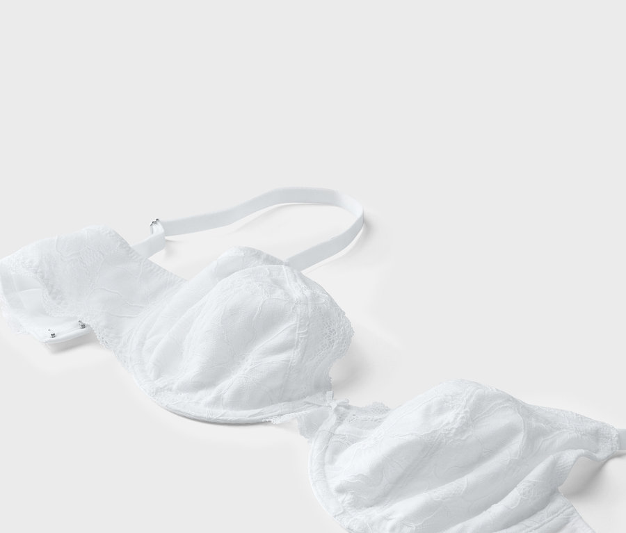 Vue détaillée d'un soutien-gorge blanc en dentelle sur fond blanc.