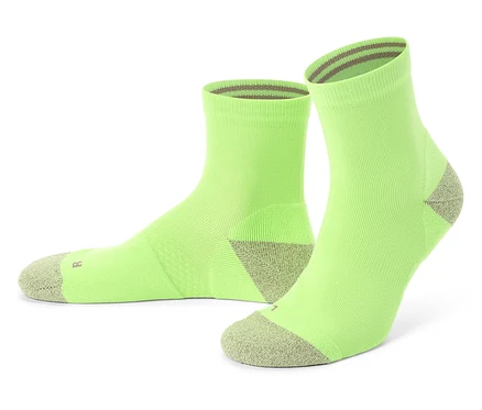 Deux chaussettes vert clair avec des bouts et des bords-côtes gris se tiennent sur un fond blanc.