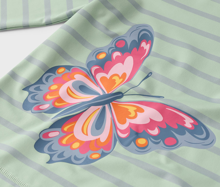 Gros plan d'un tissu vert clair rayé avec un grand imprimé papillon rose, orange et bleu.
