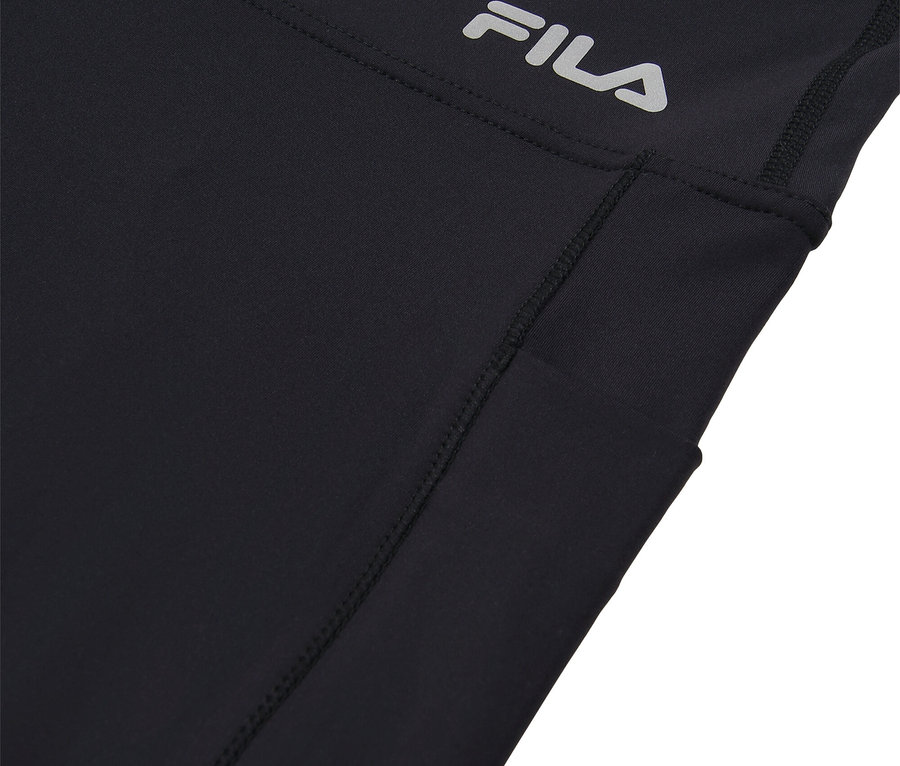 Gros plan sur un pantalon de sport Fila noir avec une poche latérale et un logo Fila argenté.