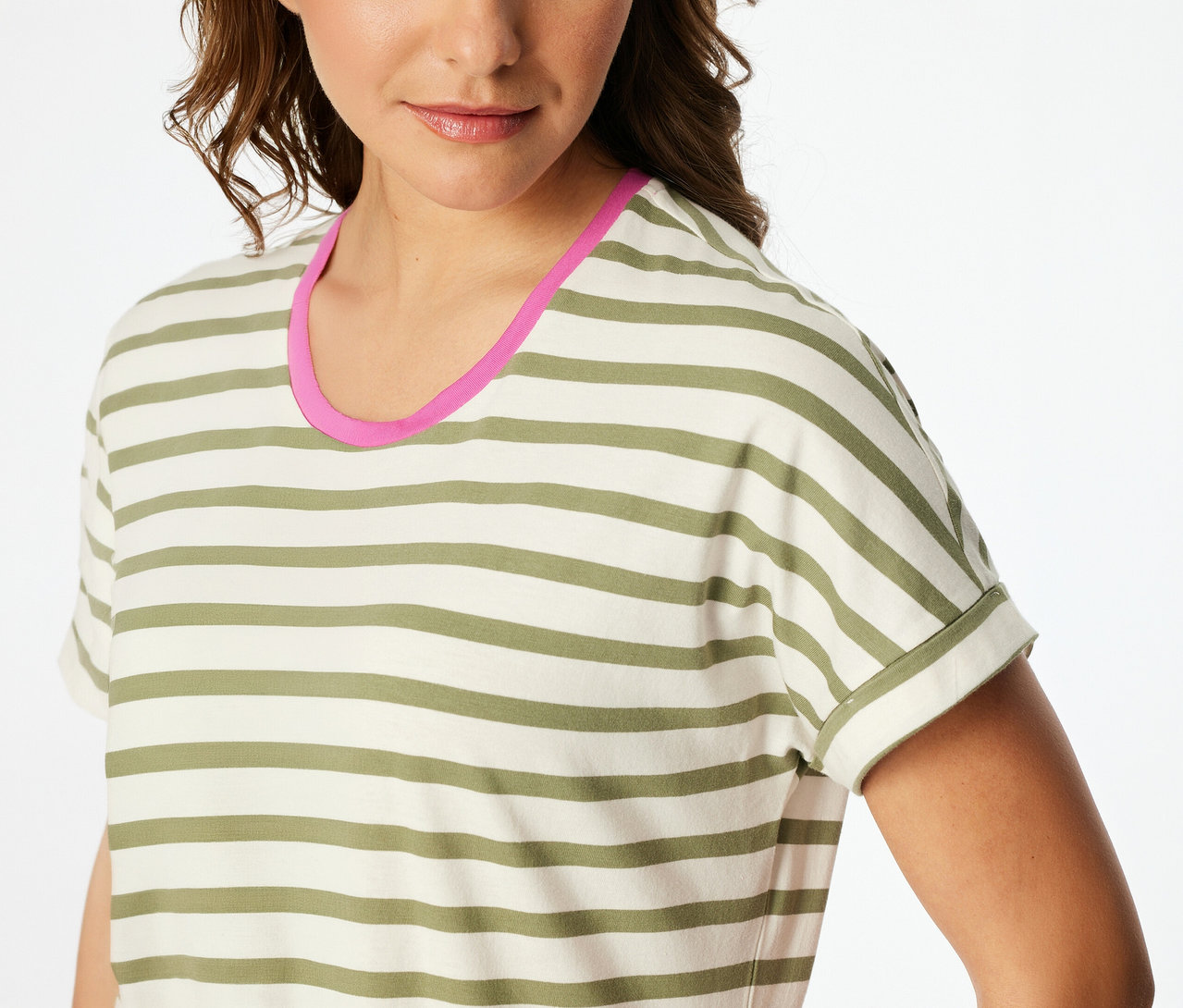 Une femme porte une chemise de nuit SCHIESSER rayée blanc cassé et vert olive avec un col rond bordé de rose.