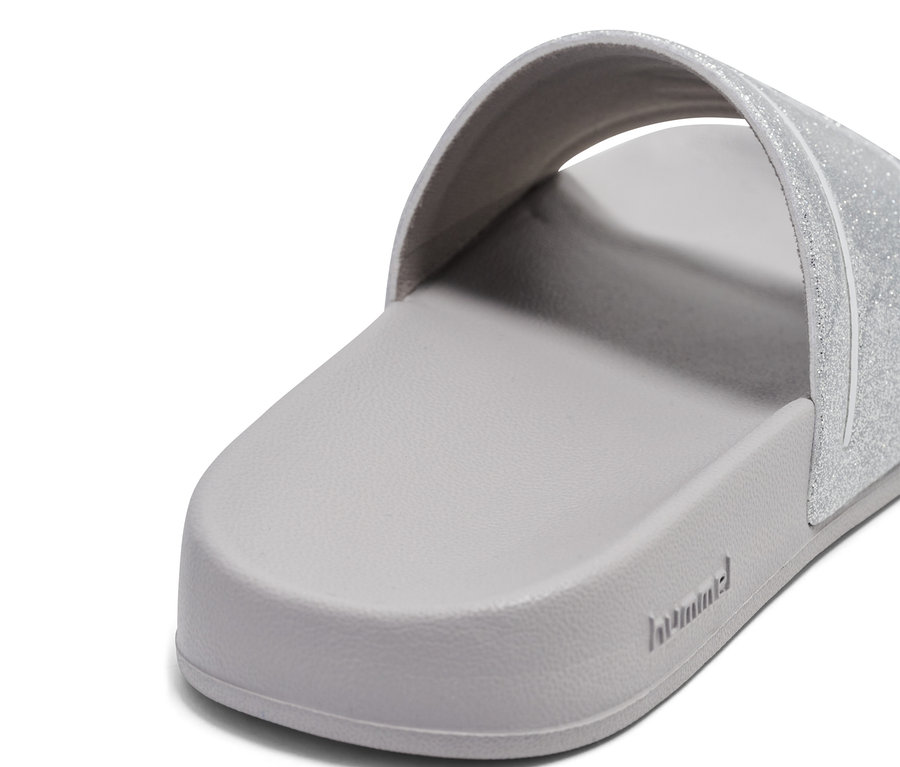 Gros plan d'une unique tong de bain hummel® Pool Slide GlitterJR grise avec une bride pailletée.