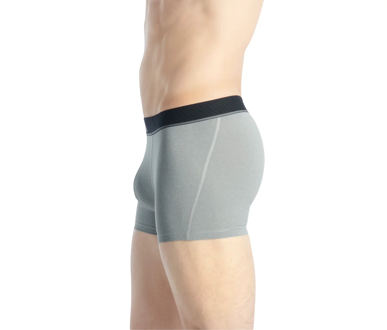 Un homme porte un boxer gris avec une ceinture noire et une bande grise, photographié de profil.