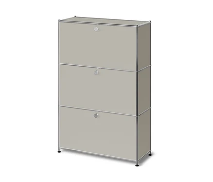 Armoire modulaire beige clair avec trois portes abattantes et un cadre chromé, reposant sur de courts pieds noirs.