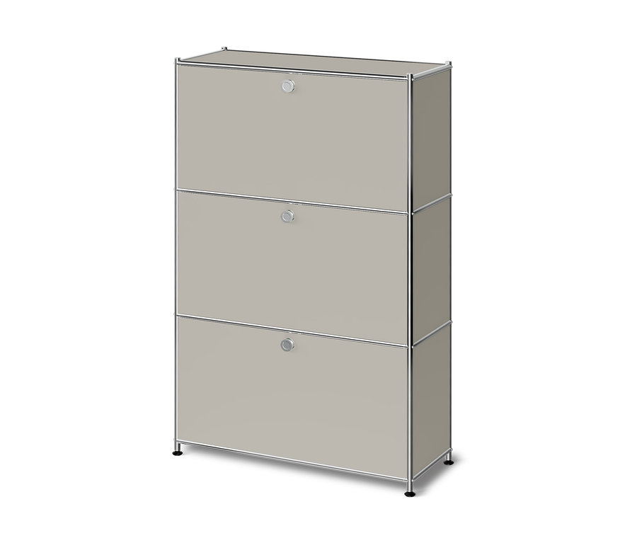 Armoire modulaire beige clair avec trois portes abattantes et un cadre chromé, reposant sur de courts pieds noirs.