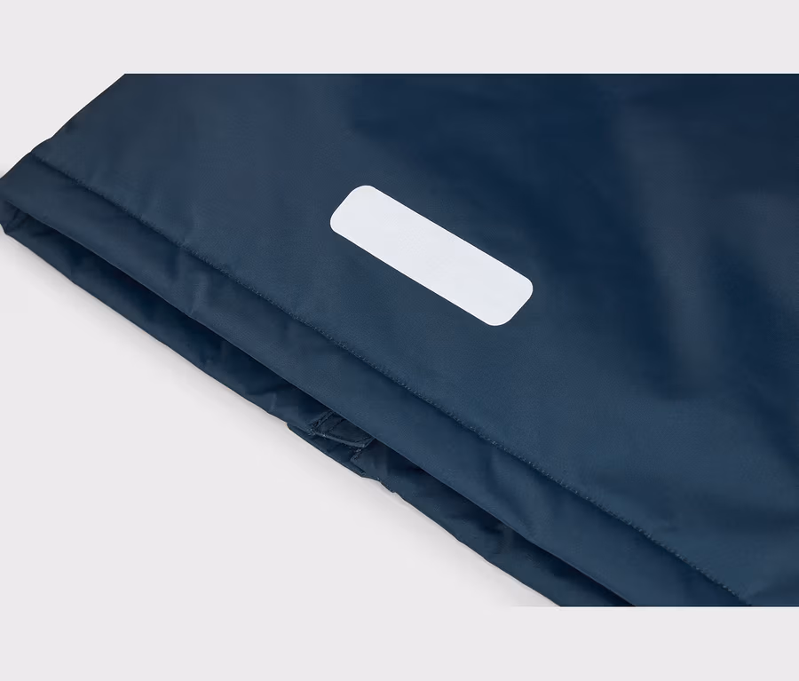 Gros plan sur un tissu bleu foncé avec une bande réfléchissante blanche et rectangulaire.