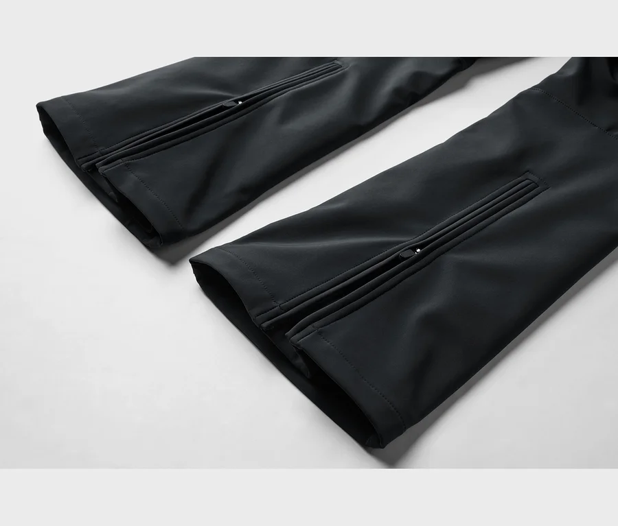 Deux jambes de pantalon noires, chacune avec une fermeture éclair sur le côté extérieur du revers.