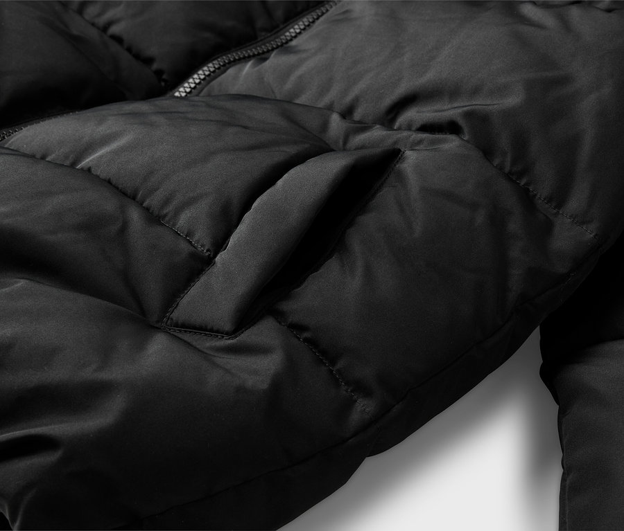 Gros plan d'une doudoune noire montrant sa texture matelassée, une fermeture éclair partiellement visible et une poche latérale verticale.