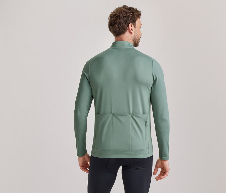 Homme de dos, portant un maillot de cyclisme vert à manches longues avec des poches arrière et un cuissard noir.