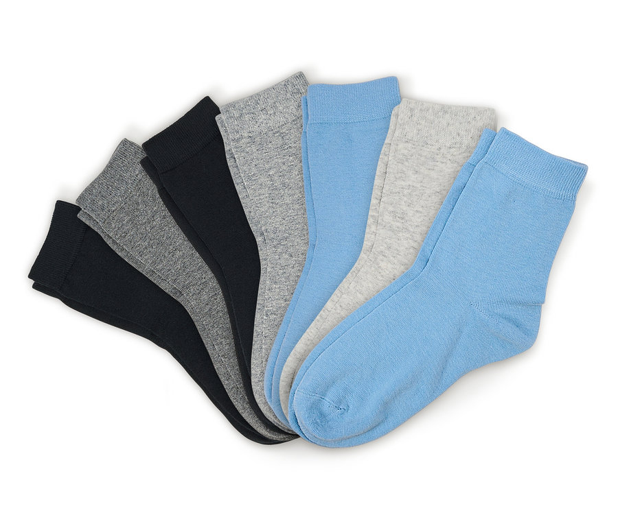 Sept chaussettes noires, grises et bleu clair, étalées en éventail sur un fond blanc.