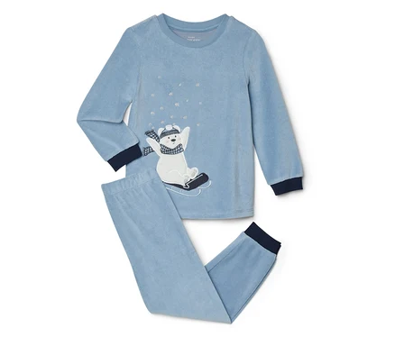 Pyjama en velours bleu clair avec un haut à manches longues et un pantalon long. Le haut présente un ours polaire blanc brodé sur une luge noire, portant un bonnet et une écharpe rayés, entouré de flocons de neige argentés. Les poignets et les chevilles sont bleu foncé.