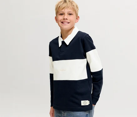Garçon blond souriant portant un pull polo Jack&Jones rayé bleu marine et blanc avec un col blanc.