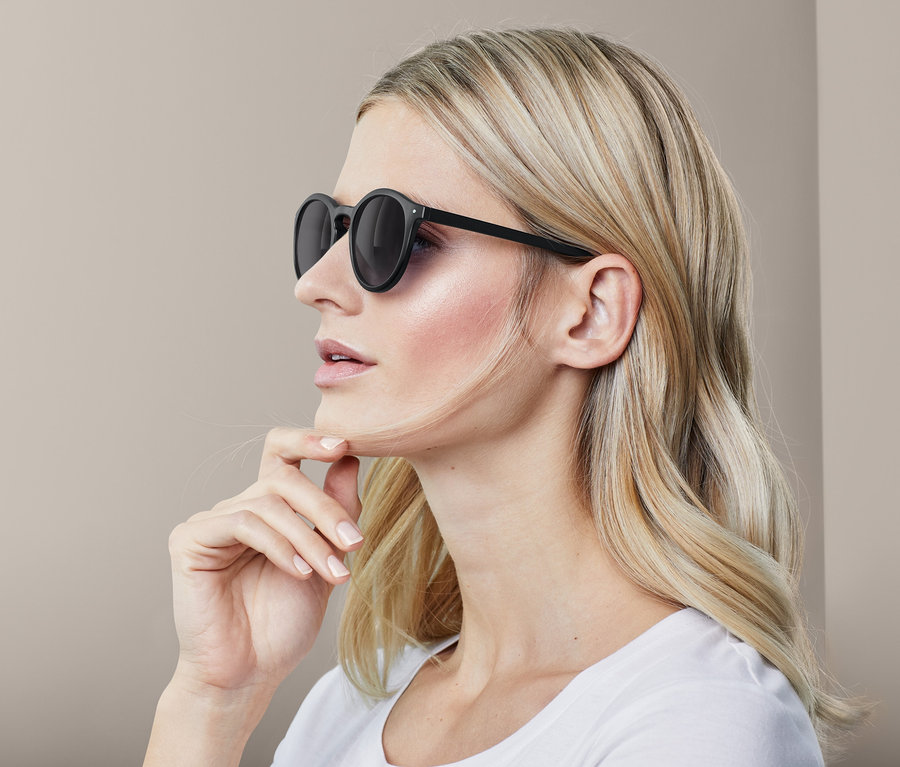 Profil d'une femme blonde portant des lunettes de soleil noires.