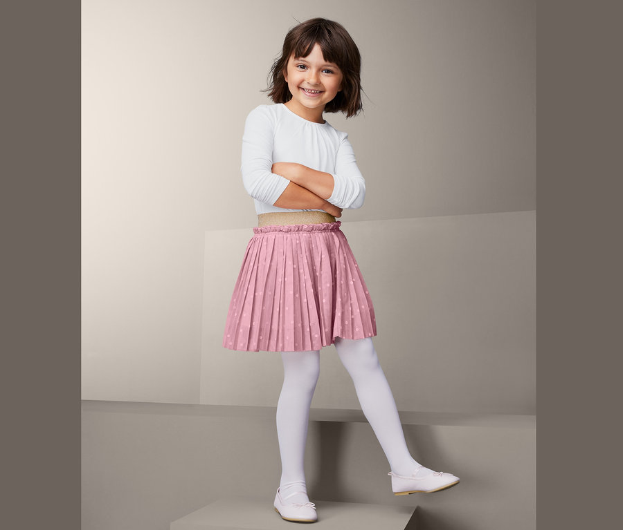 Fillette souriante posant en jupe en tulle.
