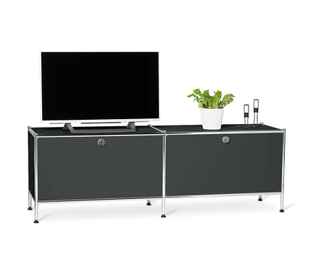 Meuble bas en métal noir « CN3 » à abattants. Une télévision, une plante en pot et deux bougies sont posées sur le meuble.