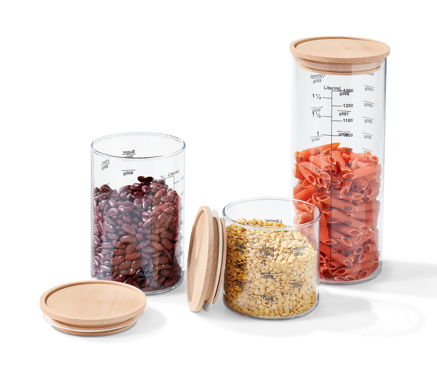 Trois ensembles de boîtes de conservation en verre avec couvercles en bois, remplis de haricots rouges, de lentilles et de pâtes.