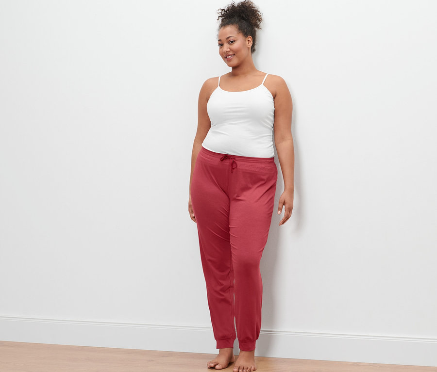 Une femme porte 2 caracos blanc et un pantalon de pyjama.