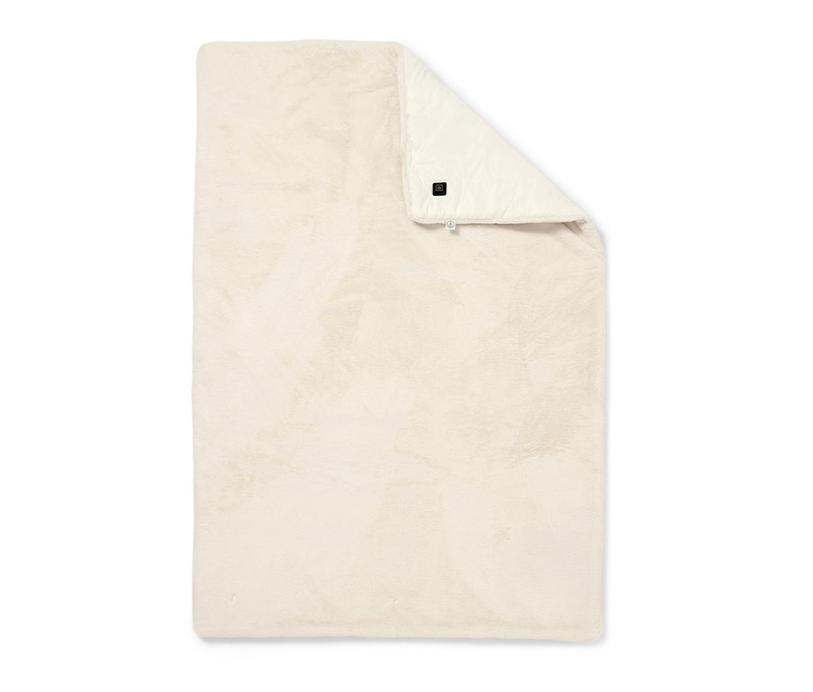 Un poncho chauffant à batterie beige plié sur un fond blanc.