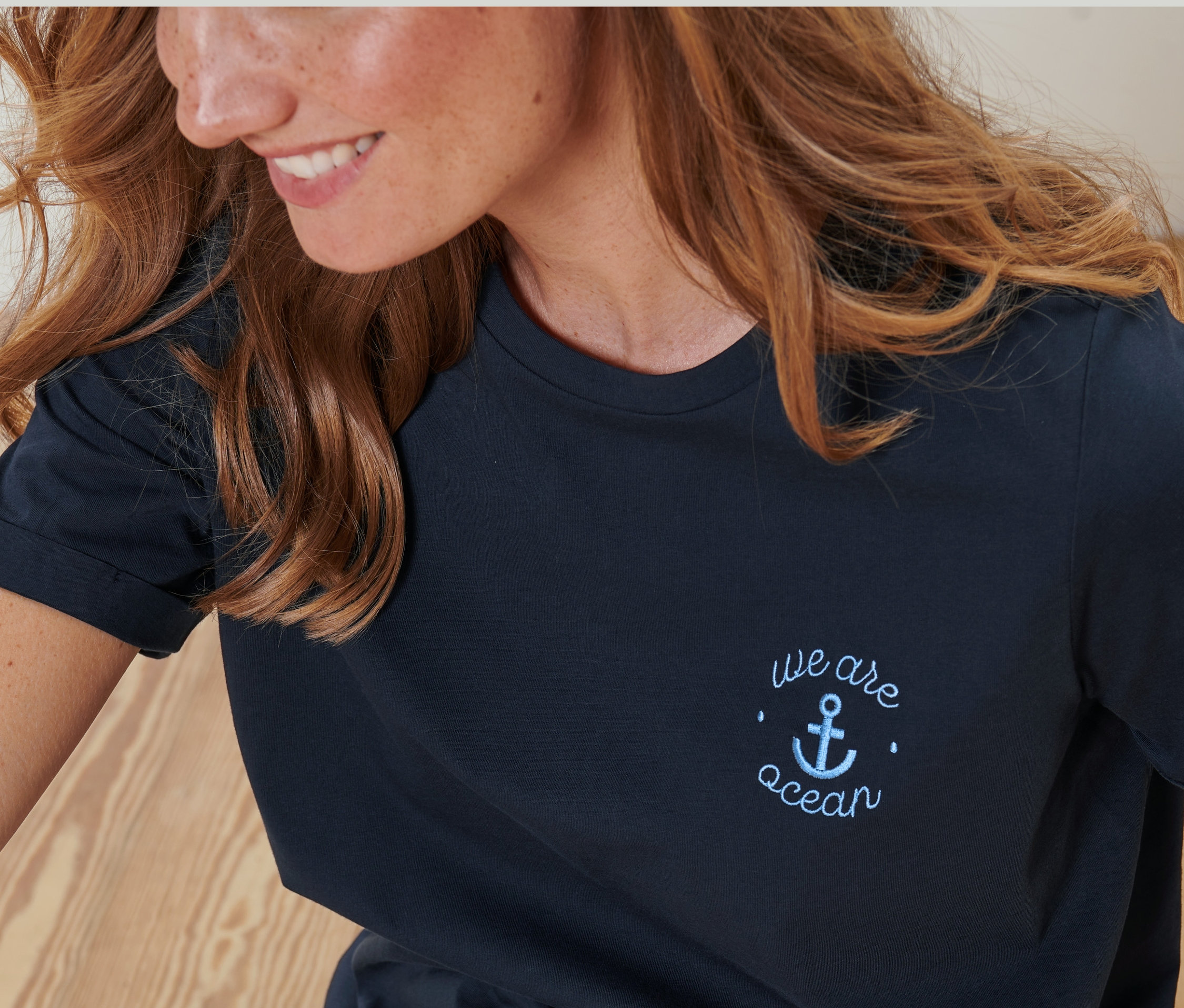 Femme portant un t-shirt à broderie bleu foncé.