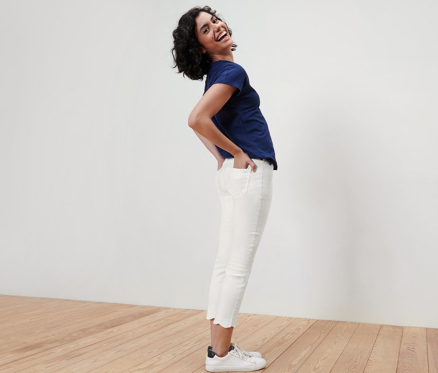 Femme posant en tregging 7/8 à broderie ajourée et t-shirt bleu.