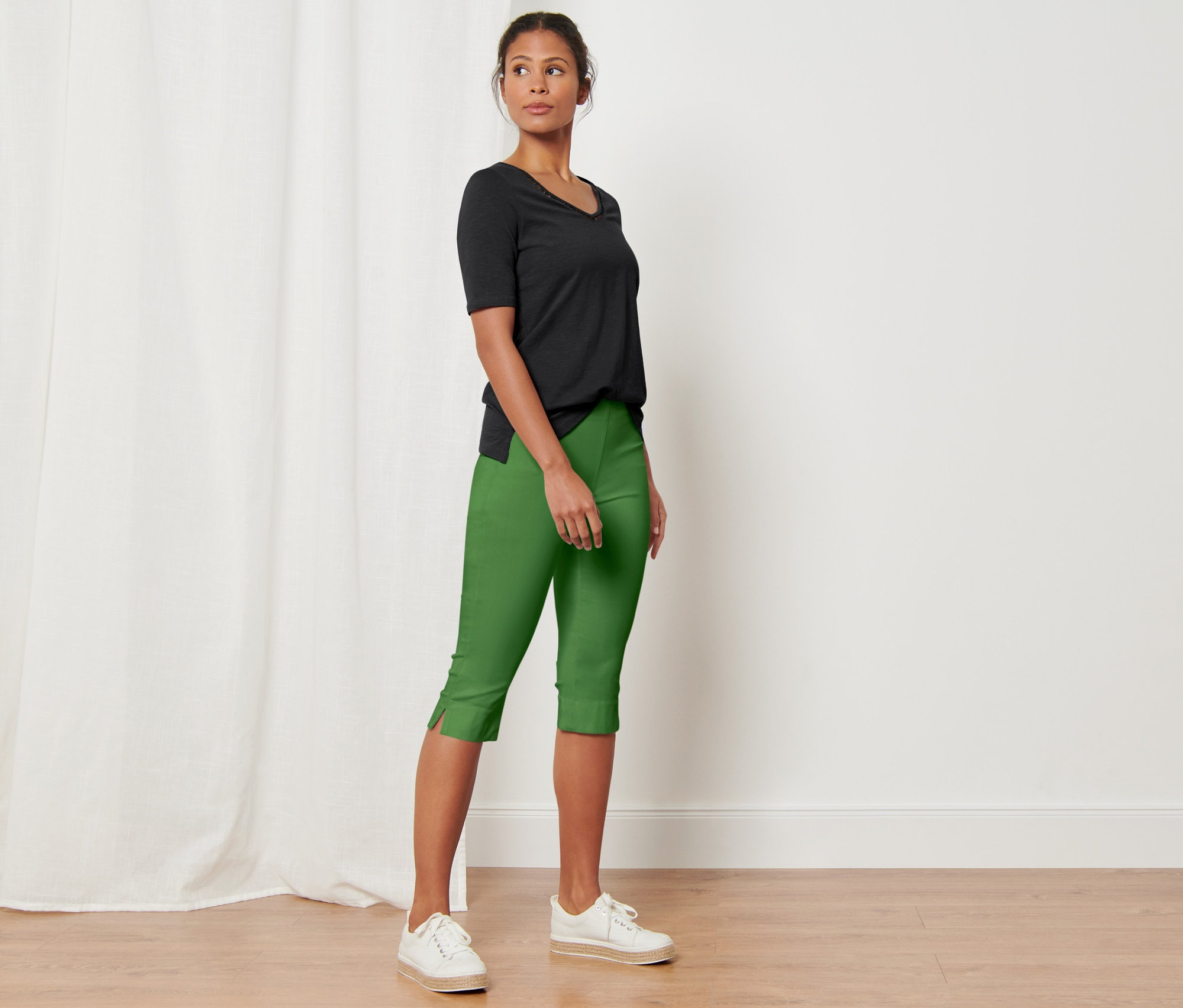 Femme posant en pantalon 3/4 stretch vert.