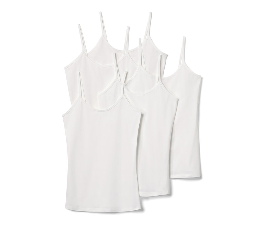Cinq chemisettes blanches à bretelles spaghetti.