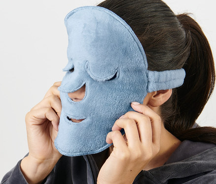 Femme mettant 2 masques pour le visage bleu clair sur son visage.