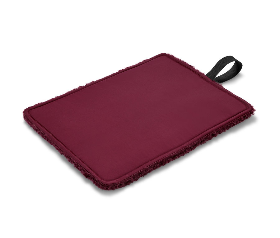Un coussin d’assise thermique pliable bordeaux avec une boucle noire.