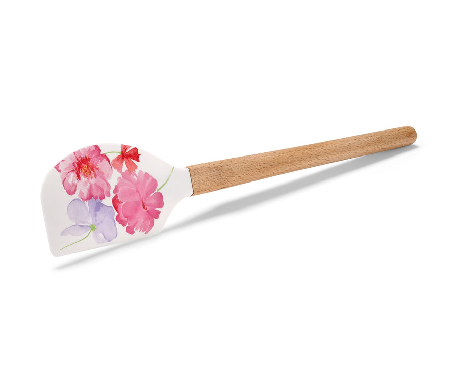 Une spatule avec un motif floral et un manche en bois.