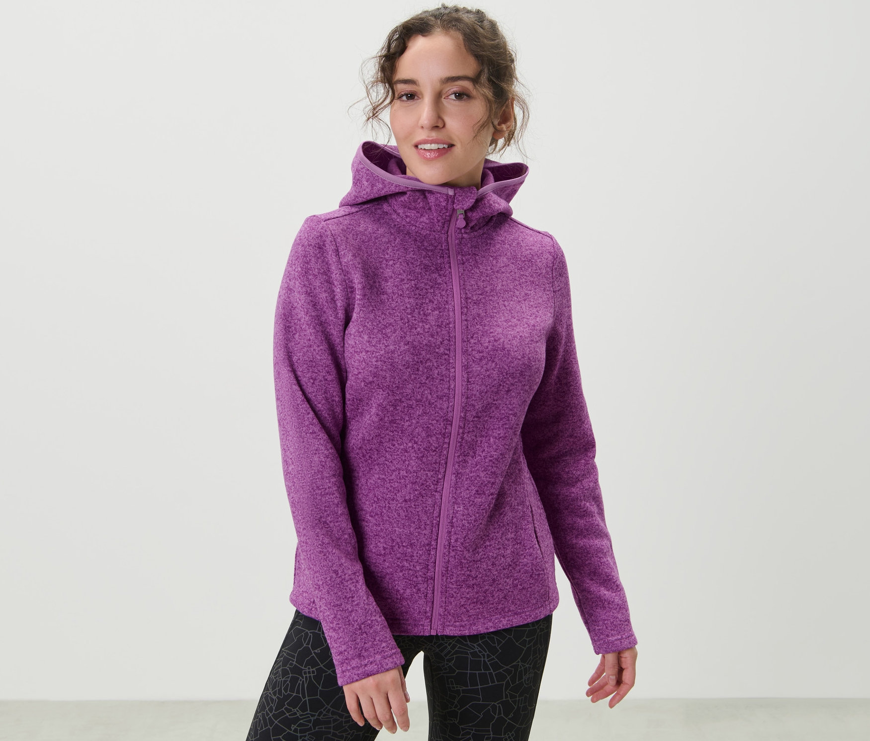 Femme portant une veste en maille polaire, rose baie.