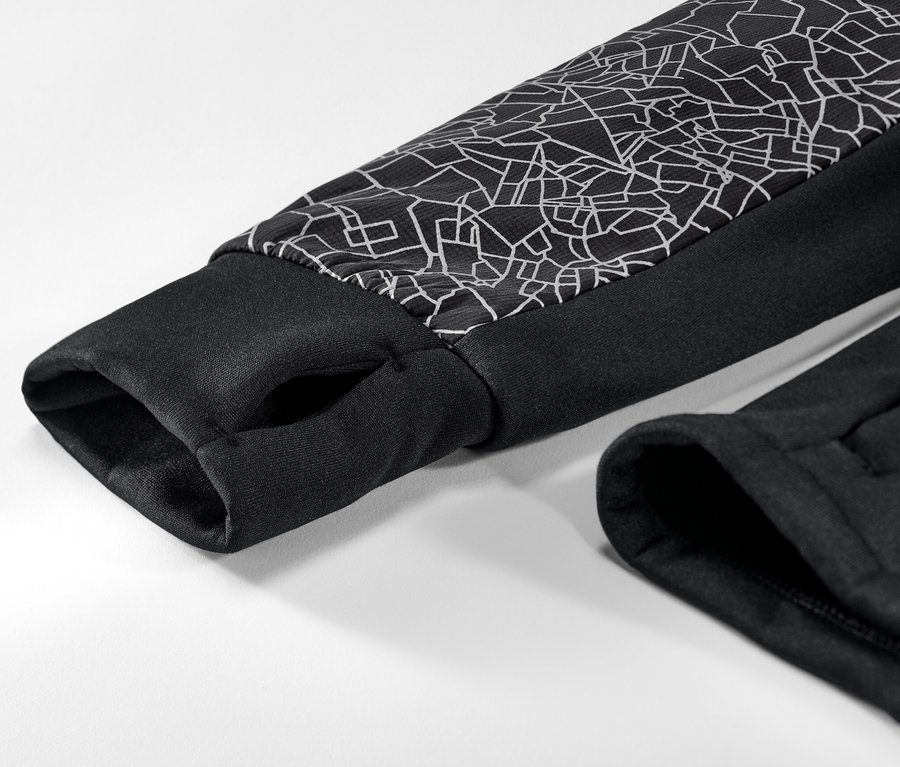 Détail d'une veste thermique avec bordure noire et motif géométrique sur la manche.