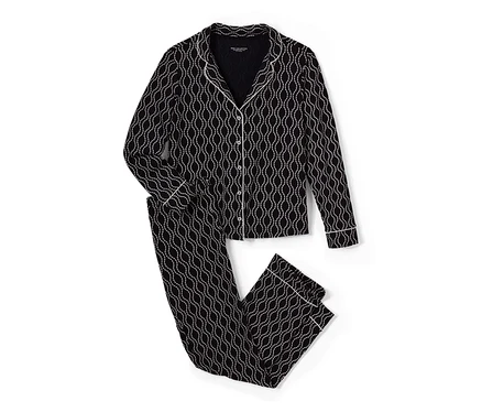 Un pyjama noir et blanc avec imprimé intégral est posé.