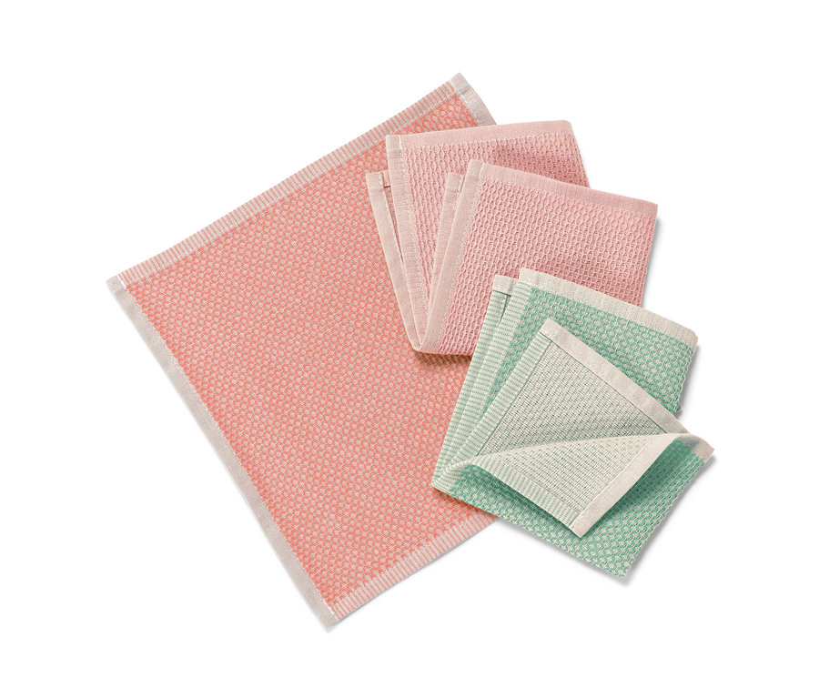 Des 3 lavettes roses et vertes sont pliées sur un fond blanc.