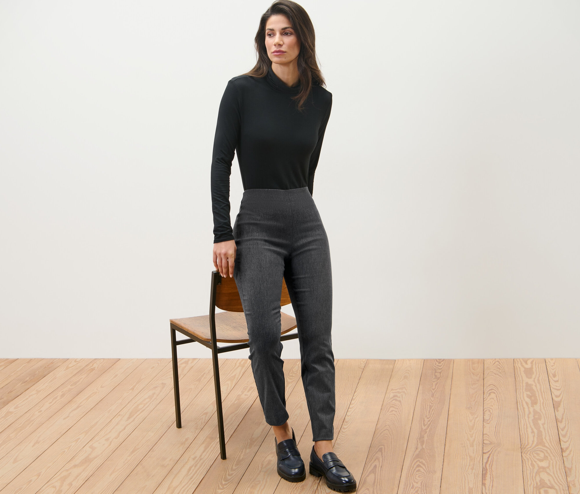 Femme posant dans un haut noir et un pantalon stretch.