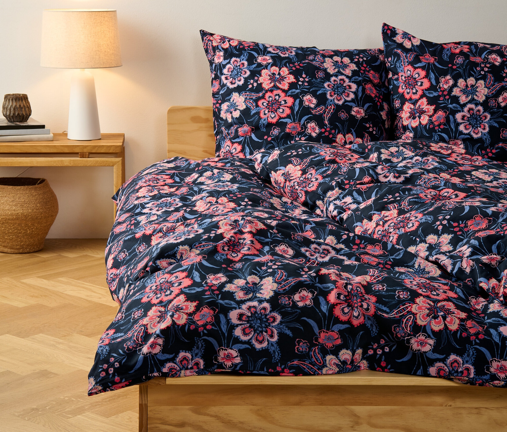 Parure de lit en renforcé bleu foncé à fleurs, taille normale, sur un lit.