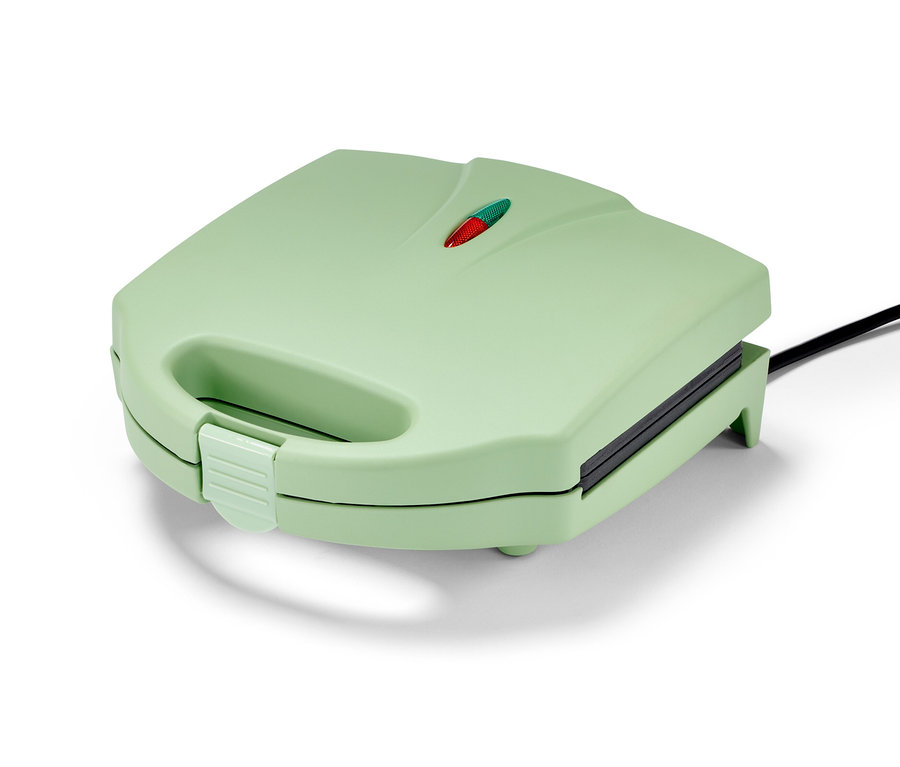 Un gaufrier vert clair fermé avec un cordon noir.