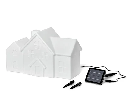 Une lampe solaire d'extérieur blanche en forme de maison, un panneau solaire et deux piquets de fixation sont présentés sur un fond blanc.
