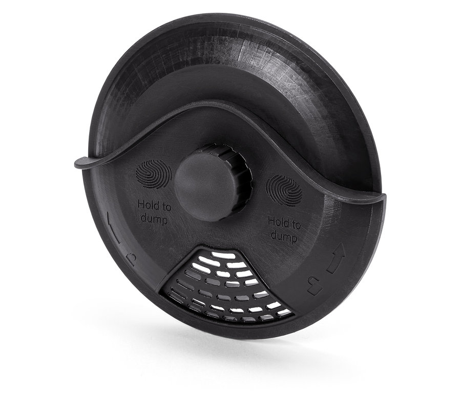 Vue détaillée d'un couvercle en plastique noir avec l'inscription "Hold to dump" et une grille.