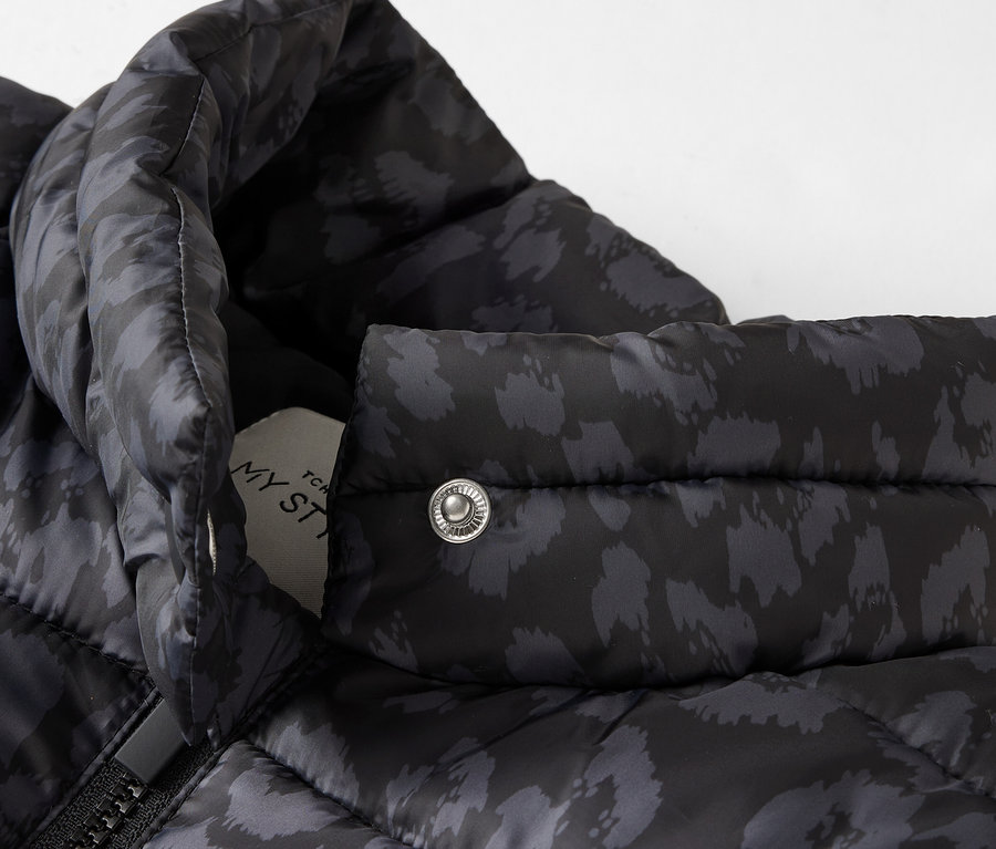 Gros plan d'une veste matelassée noire à motifs.