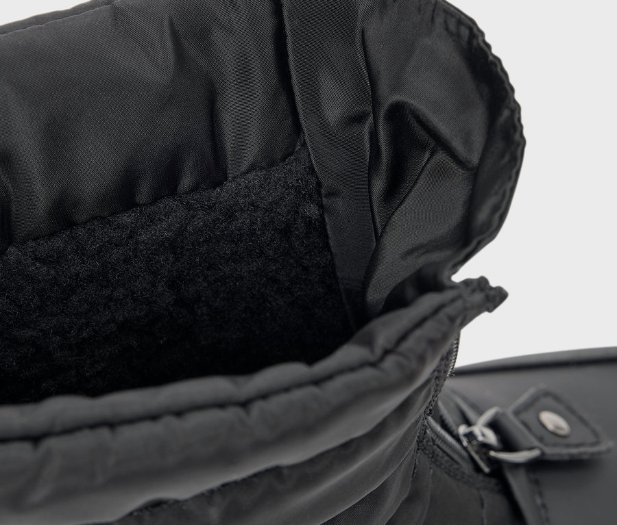 Gros plan sur une botte noire avec une doublure en polaire.