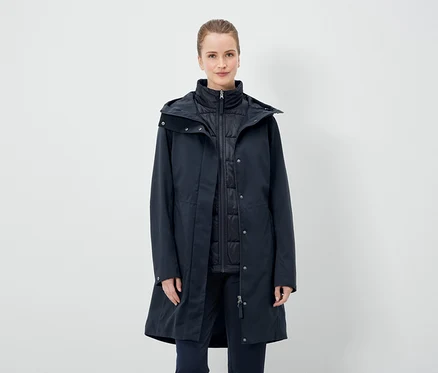 Une femme porte un manteau bleu marine et un gilet.