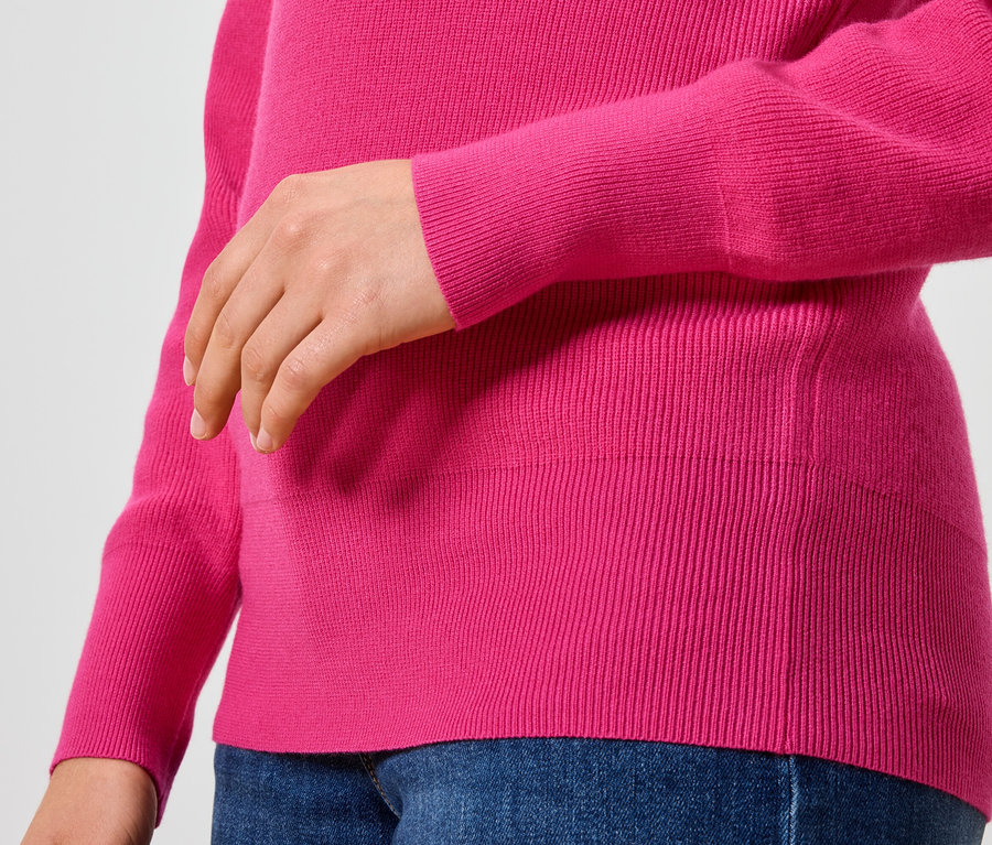 Gros plan sur un pull rose pour femme et un jean bleu.