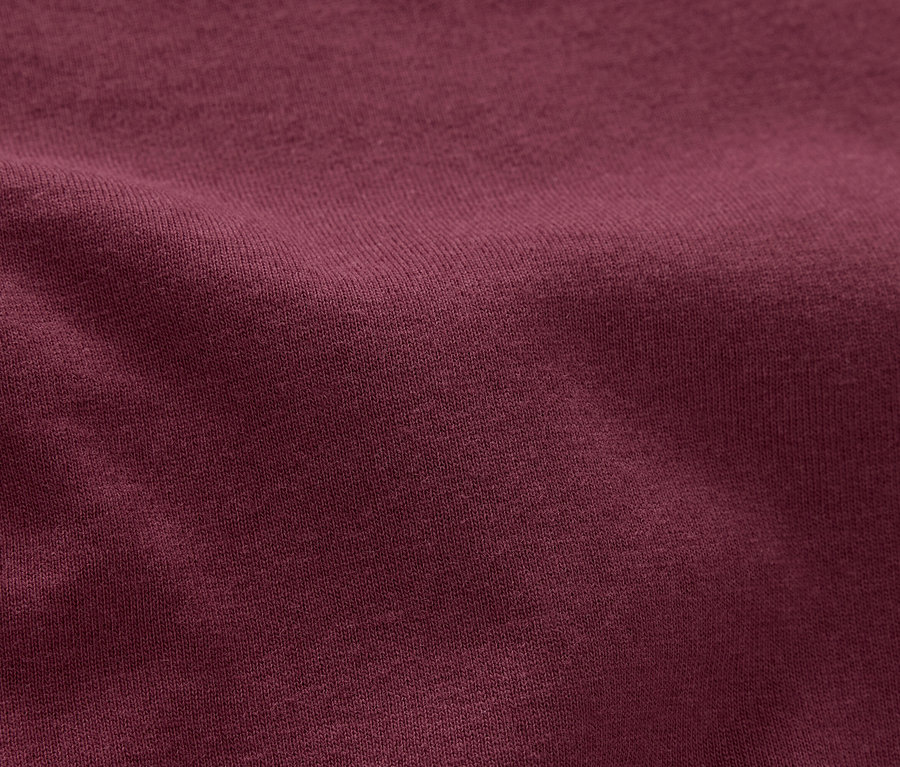 Gros plan d'un tissu texturé de couleur bordeaux.